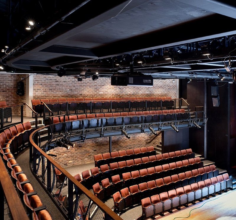 A large horseshoe-shaped plenum hidden beneath the banked rows of audience seating