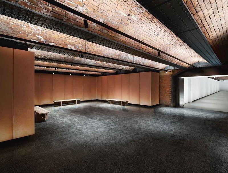 Terracotta-coloured, tactile fibreglass panels in the foyer mask the slowly weeping brick walls behind.