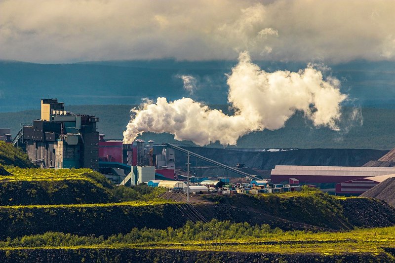 Iron ore mine smokestack emitting steam from processing plant in Sweden's Arctic Circle.