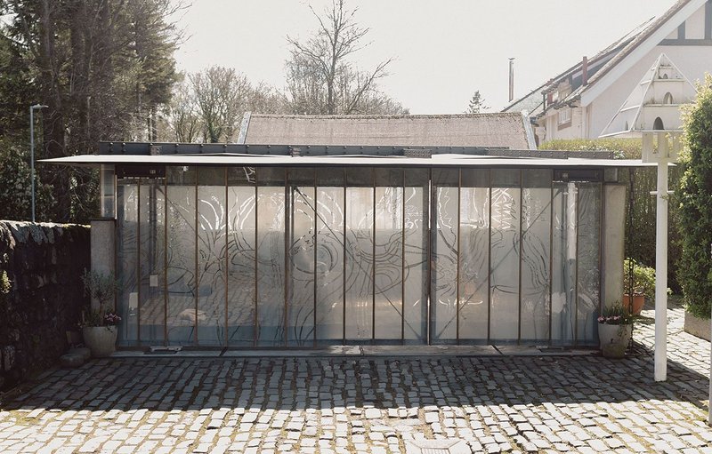 The glass and steel doors to the garage open unequally to respect the proximity of the original dovecote.