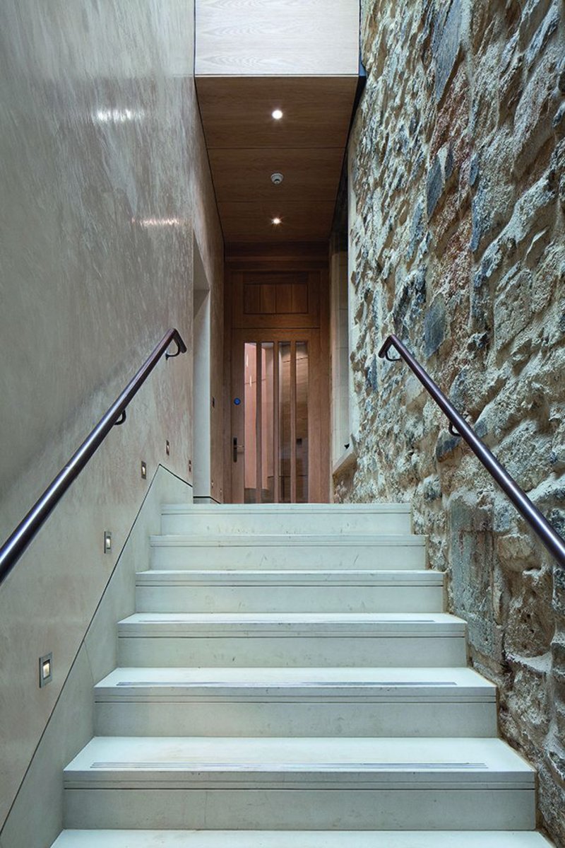 The fellows’ staircase, bronze, oak and polished plaster alongside 16th century wall.