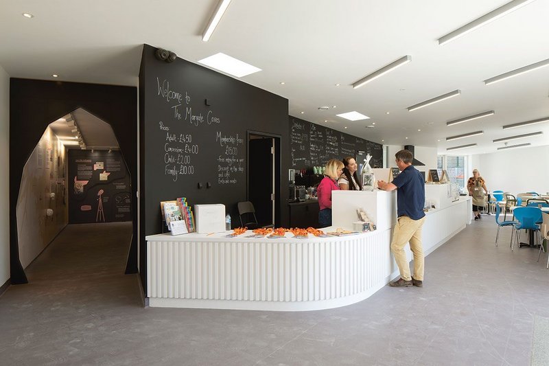 A long single counter greets visitors as they arrive. The strips of lighting recall the flint stratifications in the caves below.