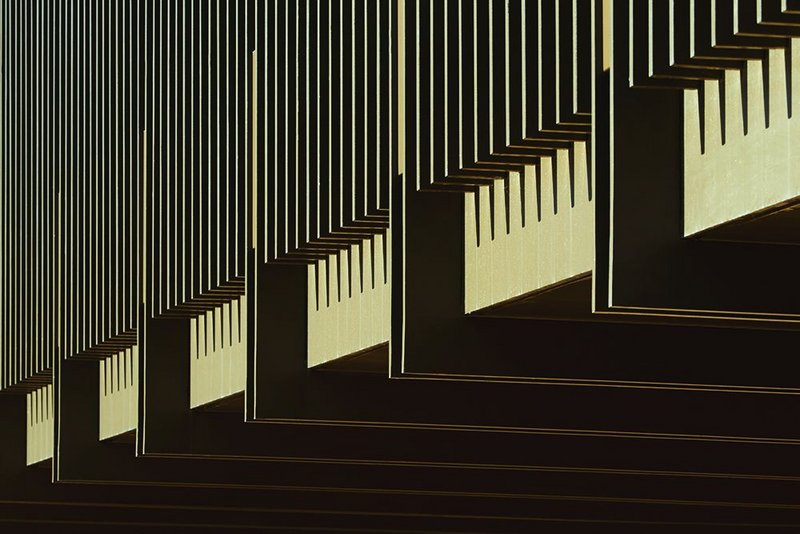 The underside of the entrance bridge, a steel balustrade giving it a delicate presence in the courtyard below.