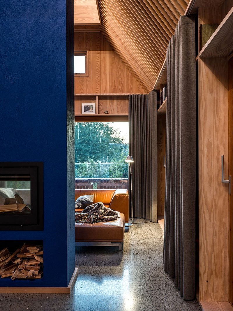 The Yves Klein blue chimney rises through the centre of the house, dividing the living space from the kitchen.
