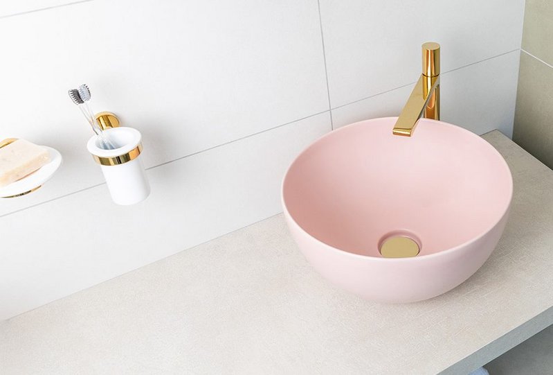 Baby pink ceramics and golden brassware bring colour and warmth to bathrooms. Bagnodesign Koy washbasin with Toko mixer, Sanipex.