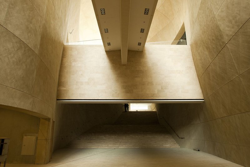 Bulbous curving concrete walls display a changing chiaroscuro of light and shade.
