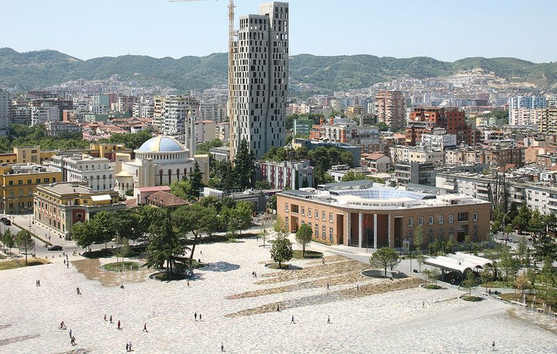 Skanderbeg Square looking south east. Unifying various ministries and public buildings around it, the reinvented square is more monumental yet more humane than in its former iteration.