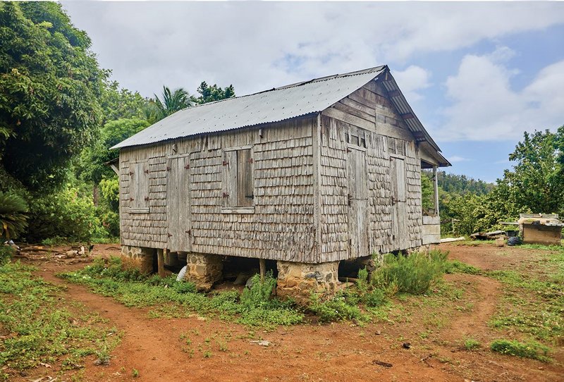 Perched on a plateau near Campbell Village, this large rural ti kai is home to a farmer Shirman Esprit, and was built by his father. It combines old and ‘new’ technologies – hand-sawn timber and a galvanised metal roof.