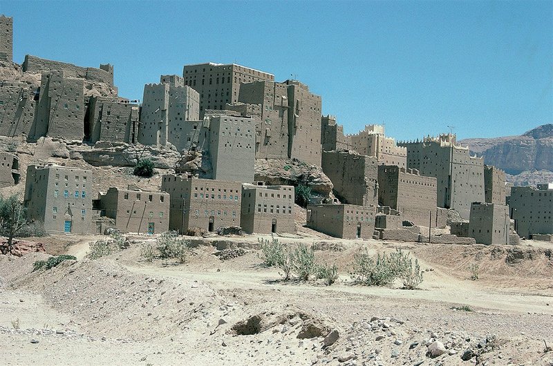 A tight cluster of mud brick towers and more recent houses along the wadi (ravine) banks in the town of Habban.