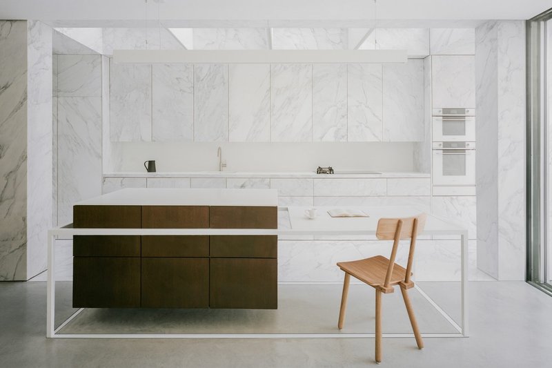 The kitchen's side extension is resplendent with marble floor, wall cladding and cabinet fronts.