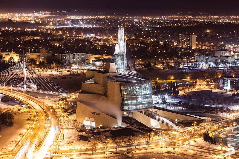 The lit tower stands above the flat night time landscape.