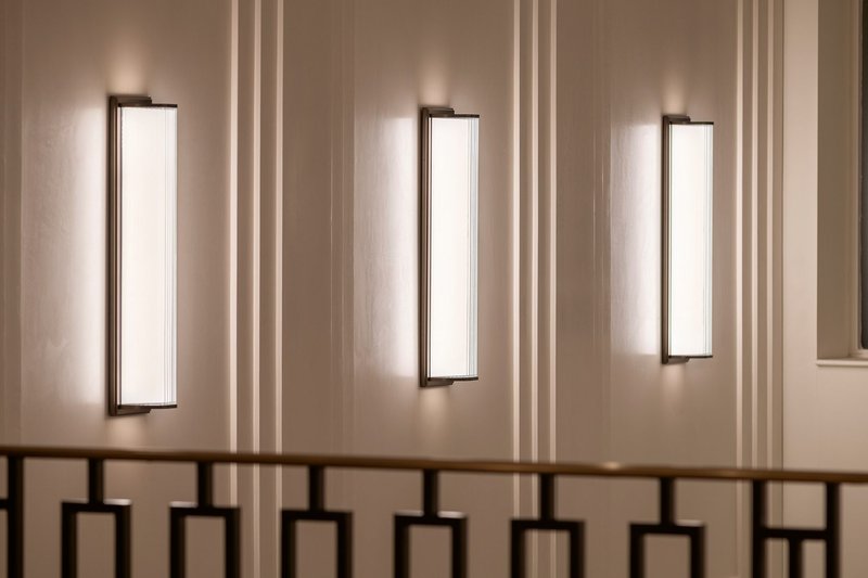 Linear lights with fluted glass covers adorn the reception wall.