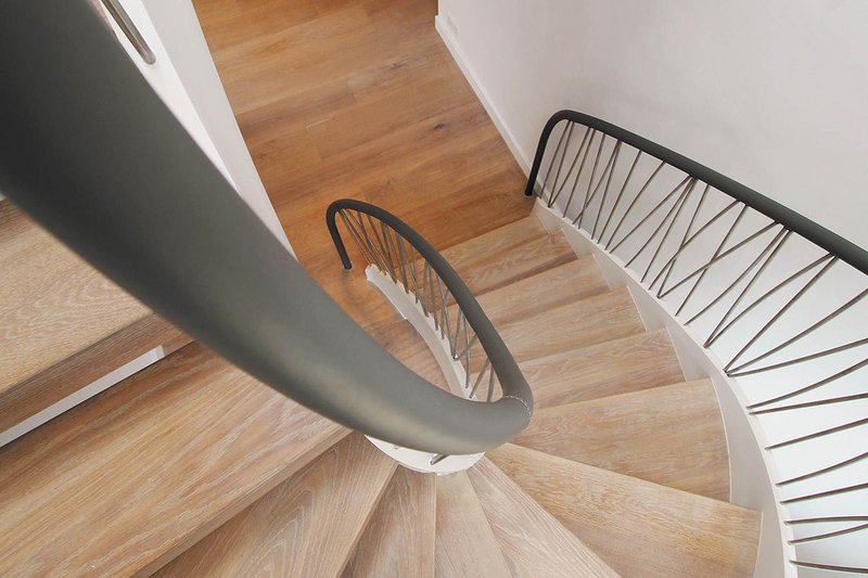 Painted steel staircase with a bespoke stainless steel spindle balustrade and leather handrail.