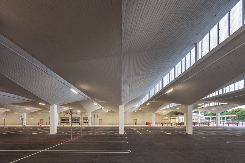 The rhythm of hyper shells and clerestory windows give newly painted concrete glory to the car park below.