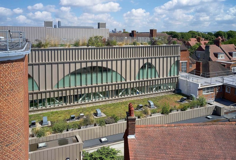 The new block fills a courtyard framed by existing buildings.