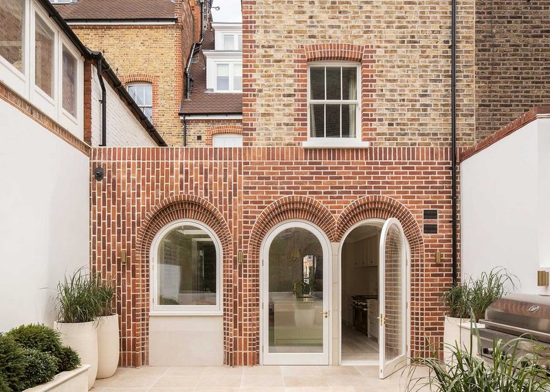 The mannered brick facade, in front of a steel frame, plays with the arch motif in its depth.