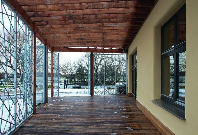 The café terrace, looking south. Galvanised grilles not only make the Eco-Hub more secure, they suggest the branches of the trees beyond