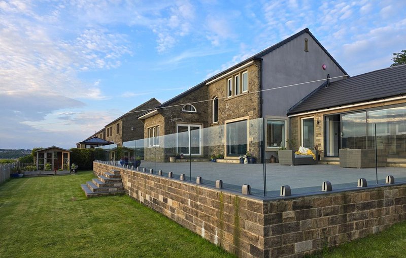 Barely there: Pure Vista's SPIG-Lite balustrade installed by Veon Glass around a raised garden patio in a domestic garden.