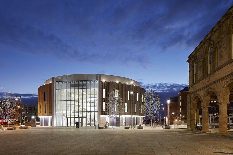 The flat full-height glazed portico plays the classical role of engaging the building with the market square.