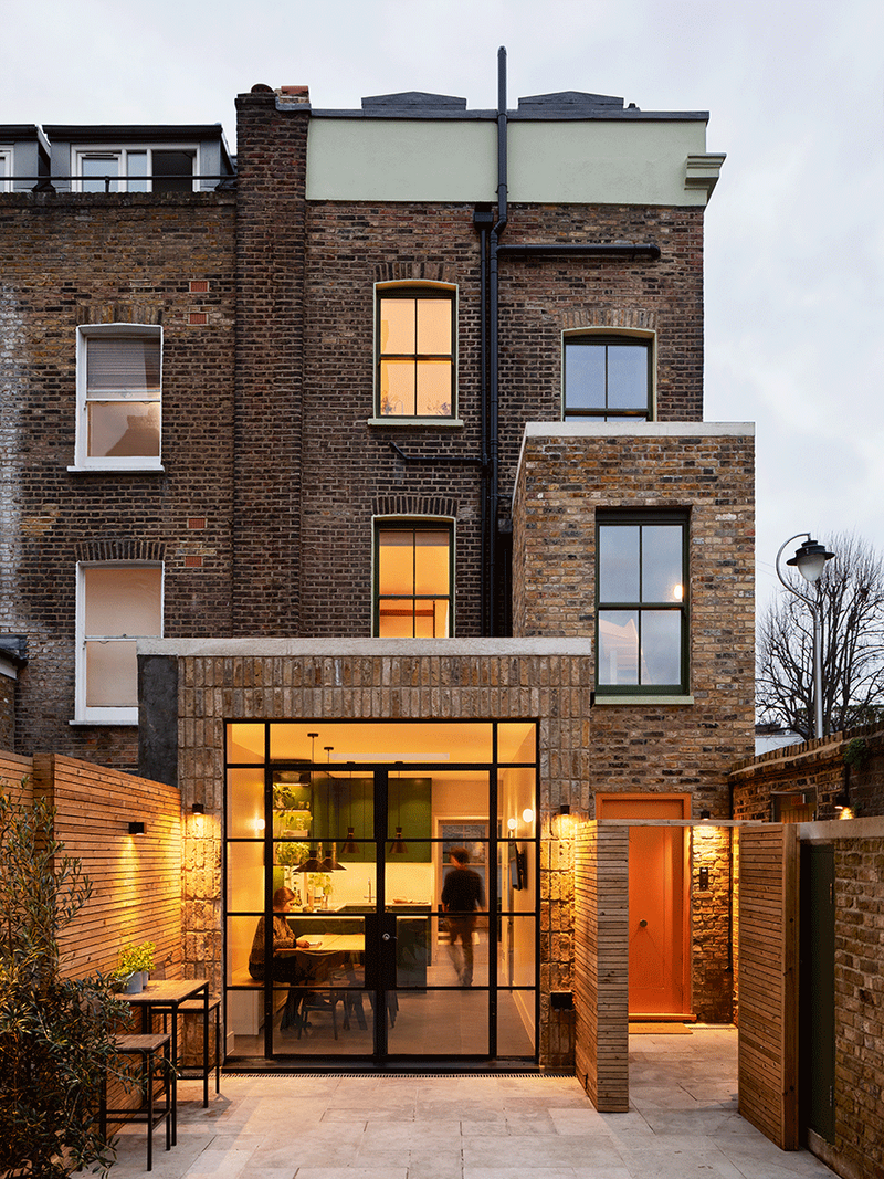 From the back garden you can see the lower flat with its Crittall screen and, to the right, the side door entrance to the upper flat.