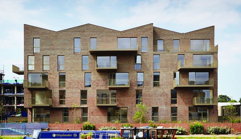 The distinctive roof form of the apartment blocks echoes the historic warehouses that once lined the Grand Union canal here.