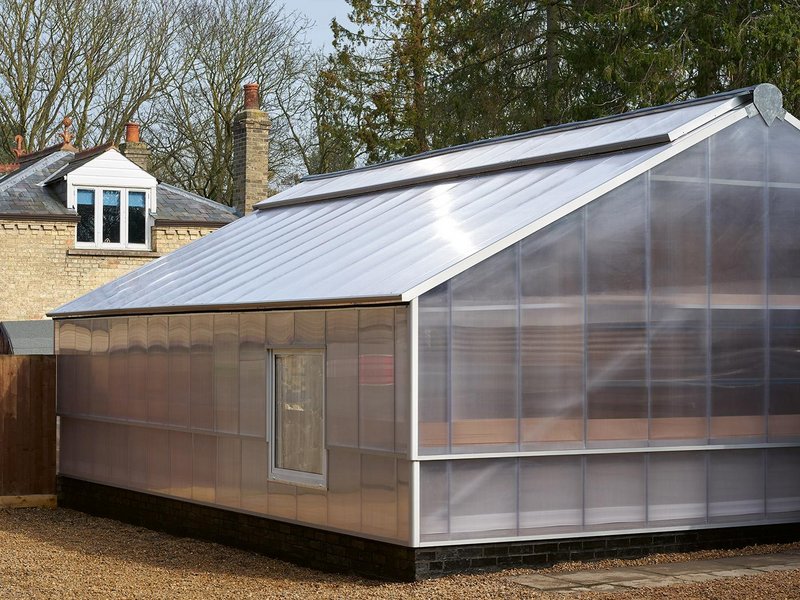 Externally, the building reads as the greenhouse that formerly occupied the site, but with a contemporary flourish hinting at a new use.