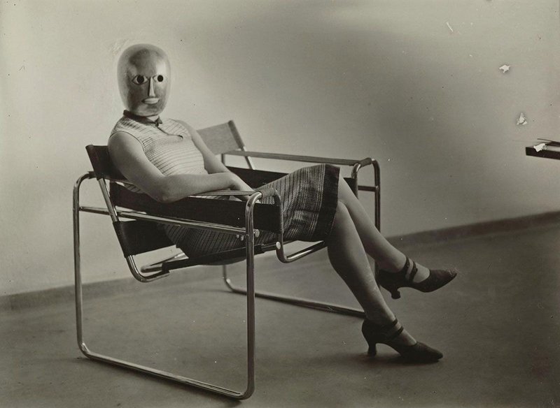 Woman on club chair B3 by Marcel Breuer, mask by Oskar Schlemmer, dress by Lis Beyer.