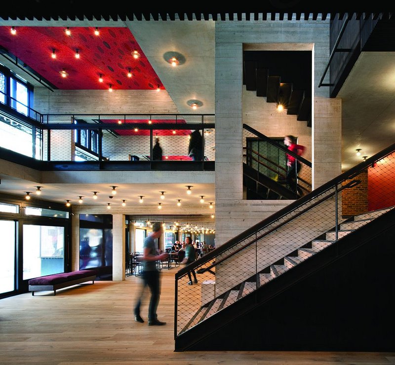 Main foyer of the new Everyman: pale boardmarked concrete, sawn oak floors, set off by Antoni Malinowski’s ceiling drawings.