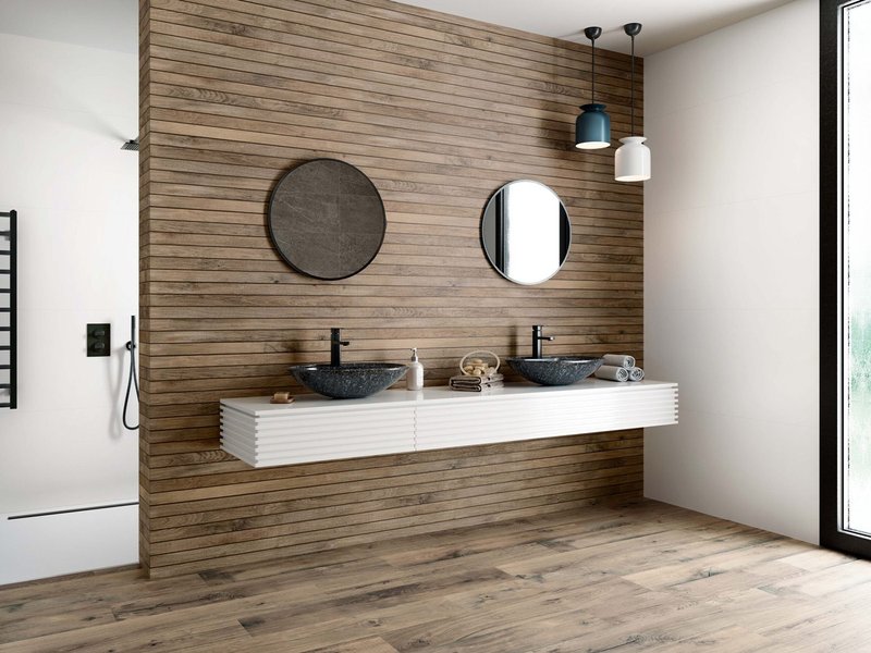 Northwood Elm by Baldocer: a wood-look rectified wall tile in a 33.3x100cm strip format with an elegant grain pattern and a subtle relief texture.
