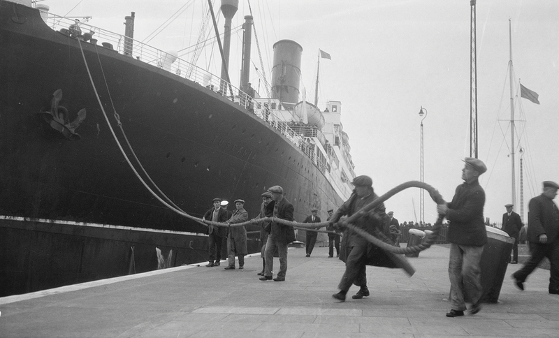PLA Lockmen hauling the warp of the 'Tuscania' along the entrance lock at the King George V Dock on 24th May, 1930