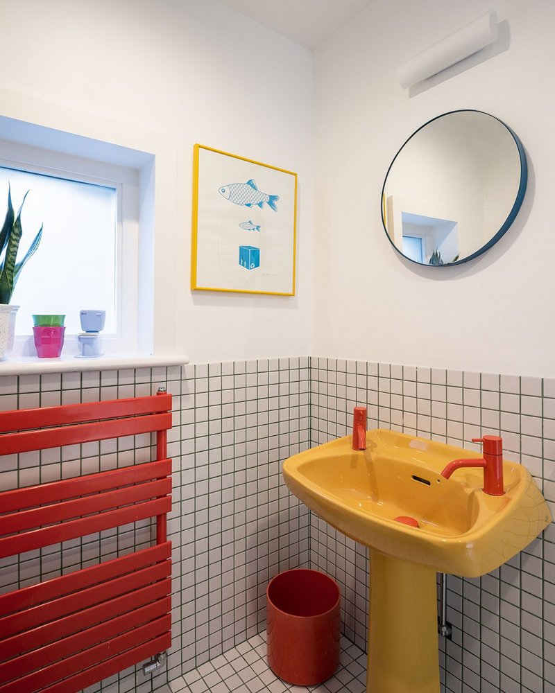 A yellow, 70s ceramic sink and high-end, red Vola fittings clash not only colours but also luxury with the discarded.