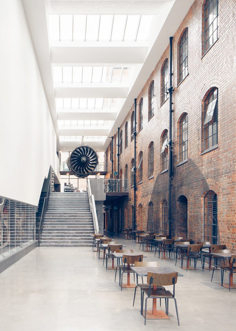 The Civic Hall or entrance atrium to the museum with a café and stairs rising to the museum shop and main exhibition galleries. A Rolls-Royce Trent jet engine dominates the space.