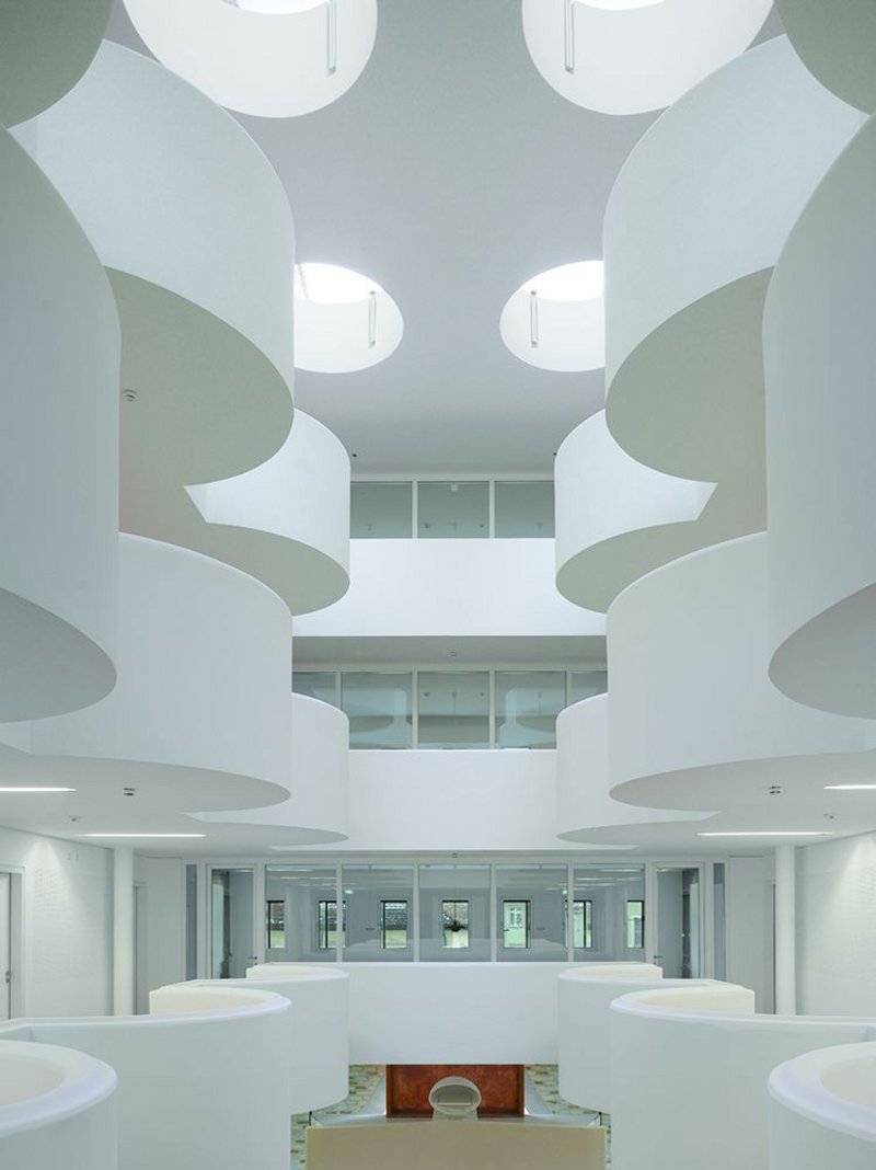 The main hall void, interrupted with semi-circular balconies, references the lost church on the site as well as evoking heavenly clouds parting.