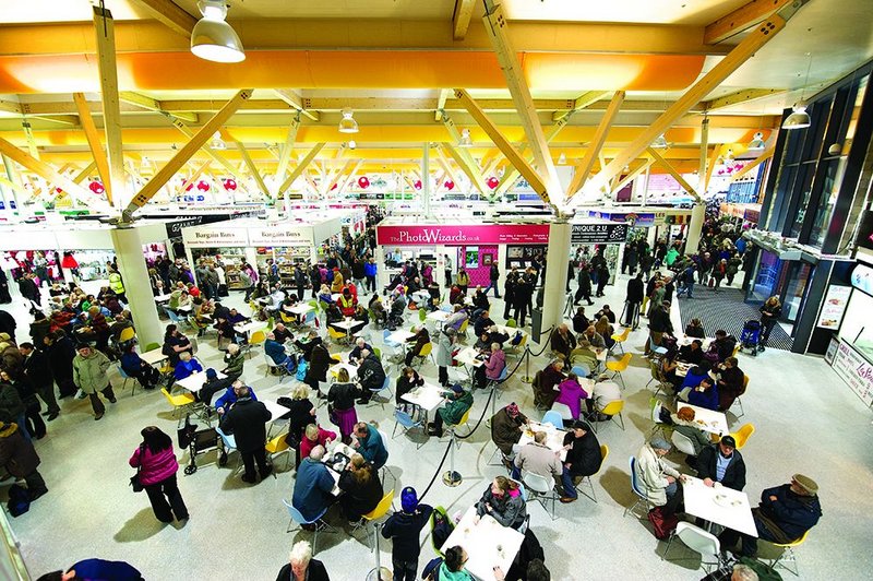 Inside, the laminated timber structure and yellow air diffusers provide a busy roofscape to the market activities.