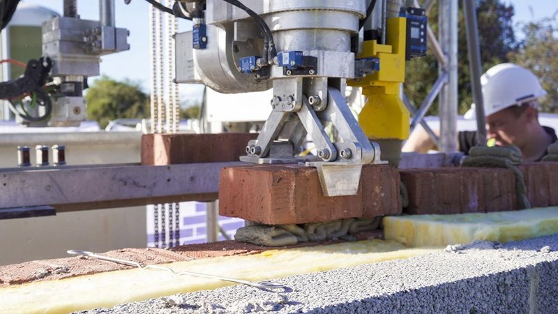 Sensors and sophisticated control software help the robot precisely align bricks of varying sizes.