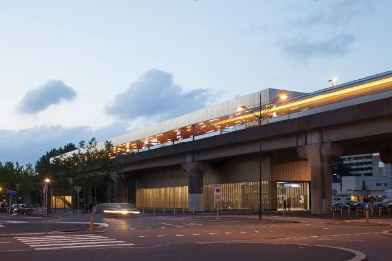 The station entrance  looking east, showing the facade’s filigree nature beneath the concrete railway tracks.