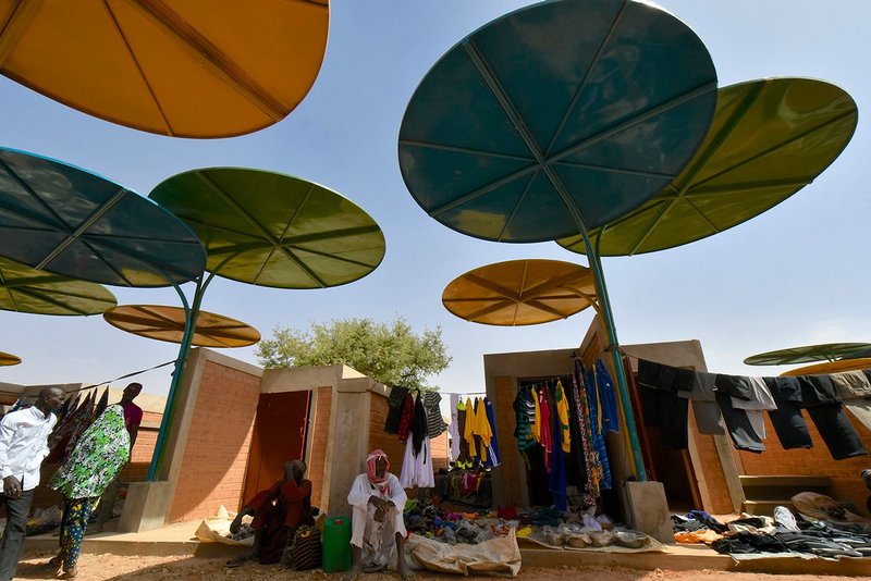The market in the village of Dandaji, Niger, 2019. The Dandaji market provides 52 enclosed stalls and colourful round canopies that shade each individual slot.