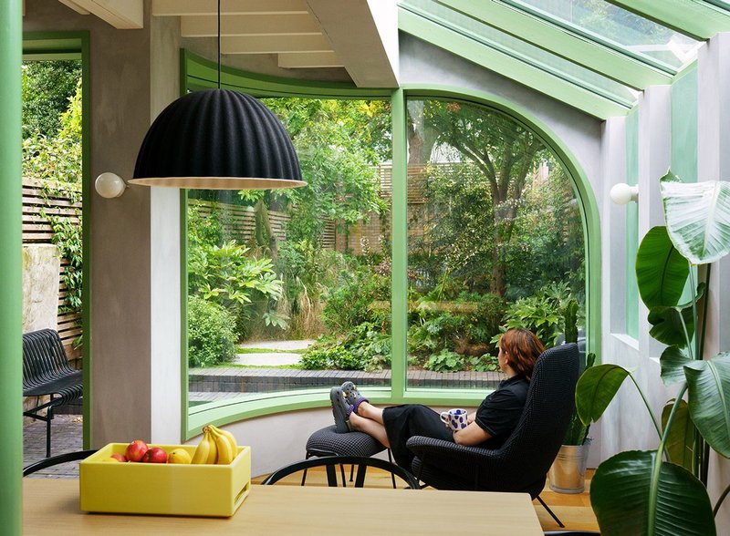 The curved window immerses people in the garden while illuminating the interior.