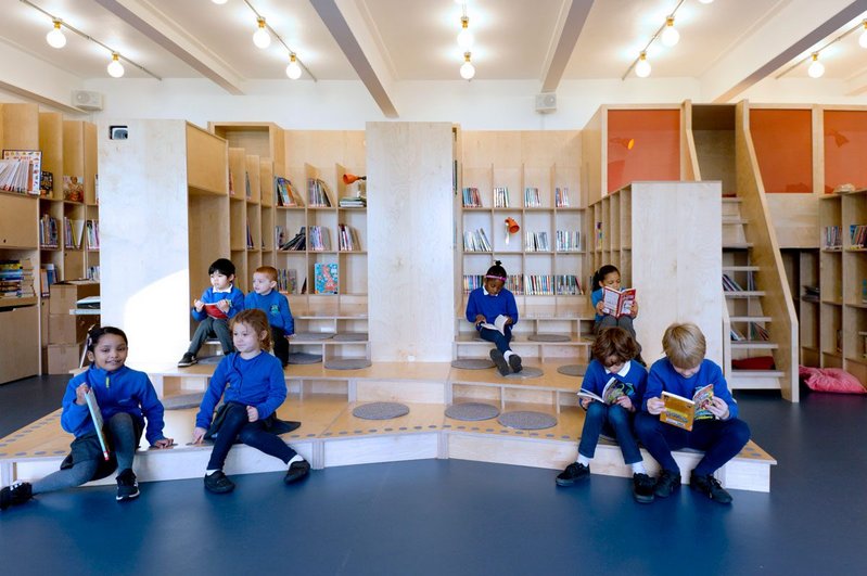 Steps form both a stage and an informal seating area in the new school library at Thornhill Primary School in London’s Islington, designed by Jan Kattein Architects.