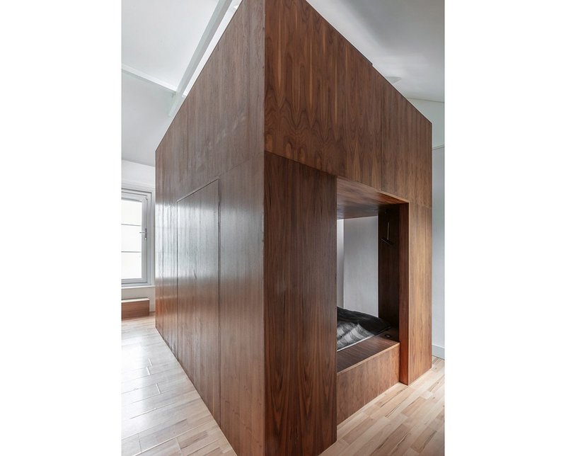 The standalone walnut box bed, here partially closed, shares the space with a walnut dresser.