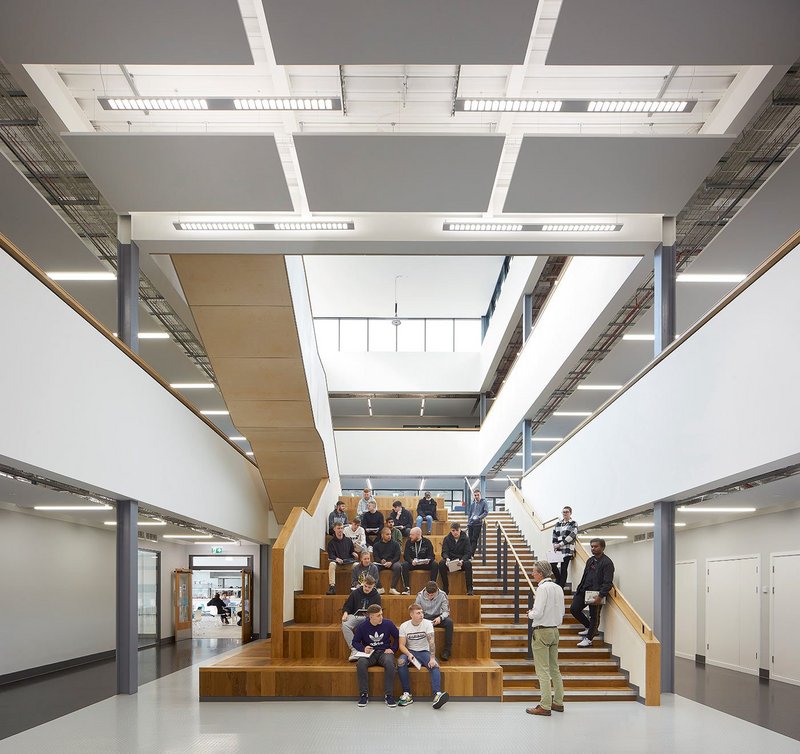 The oversized steps of the central atrium act as an informal social space, leading down from the lobby to the canteen.