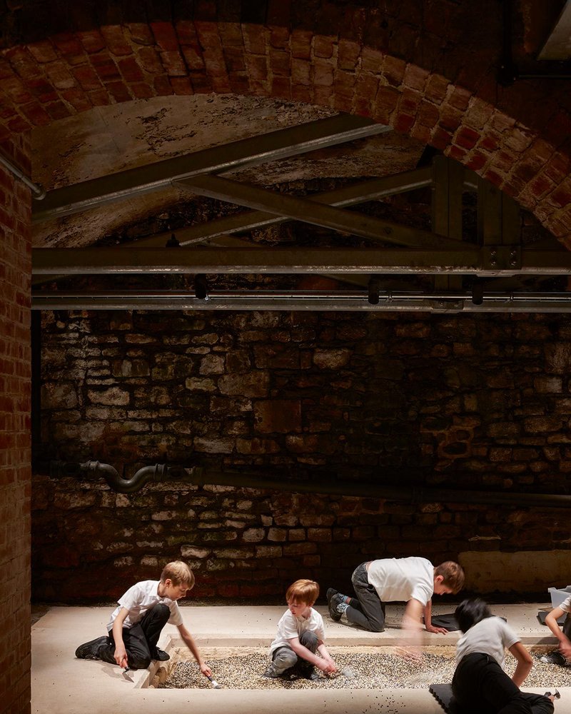 A pit in the limecrete floor, alongside the buried Roman stones, where children can do their own uncovering of ‘archaeology’.