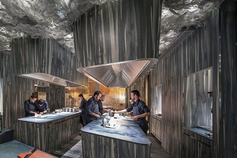 Chefs preparing dishes in the kitchen, which is clad in sintered stone.