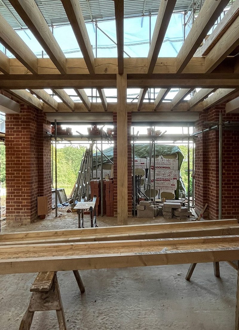 Site image of the green oak structure created by Green Oak Carpentry for a house extension in the Surrey Hills designed by Sanchez Benton. Credit: Sanchez Benton