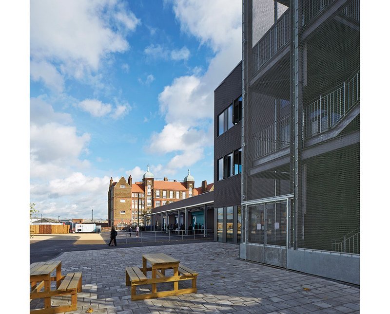 North elevation of the Greenwich UTC looking past the steel mesh external stair of the new block to the refurbished former Siemens warehouse beyond.