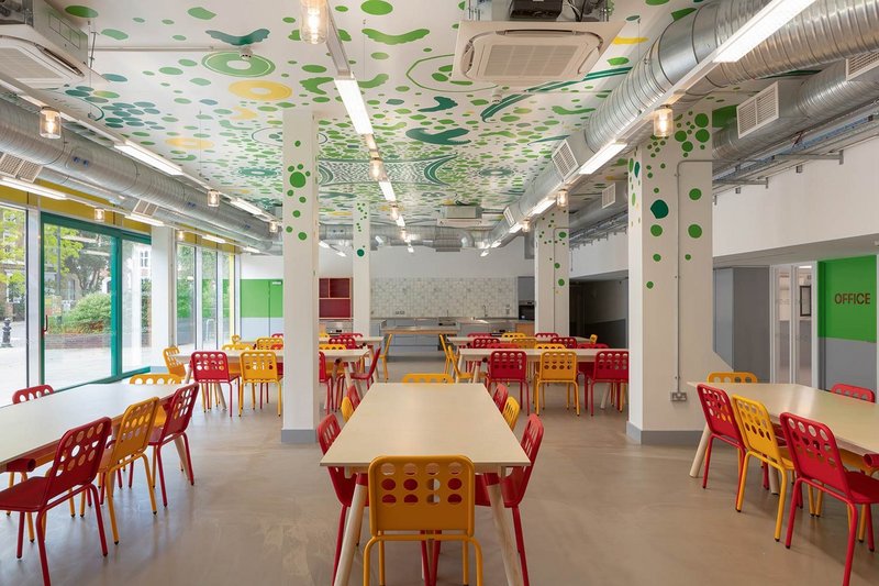 The hand-painted ceiling mural extends over the teaching kitchen at one end of the dining room.