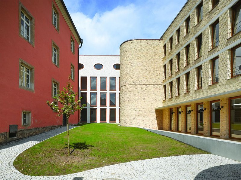The courtyard to the west of the hall embodies much of the building’s juxtaposed aesthetic. Contemporary punched windows facade with concrete lintels meet a modernist stair, a post modern office corridor and the original 17th century facade.