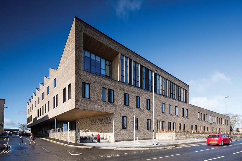 View of street corner entrance along Cushendall Road. Staff break-out and meeting rooms look out through the expanses of glazing on the second floor.