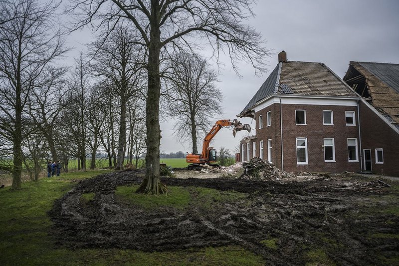 An unsalvageable farmhouse in the Groningen region being demolished because of safety concerns.