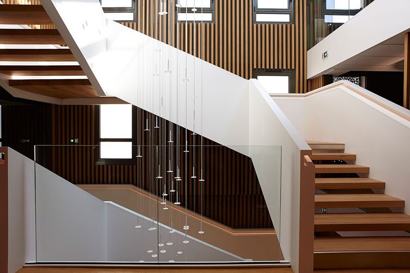 Staircase in oak and HI-MACS solid surface material at the CMMA building in Châlons-en-Champagne, France.